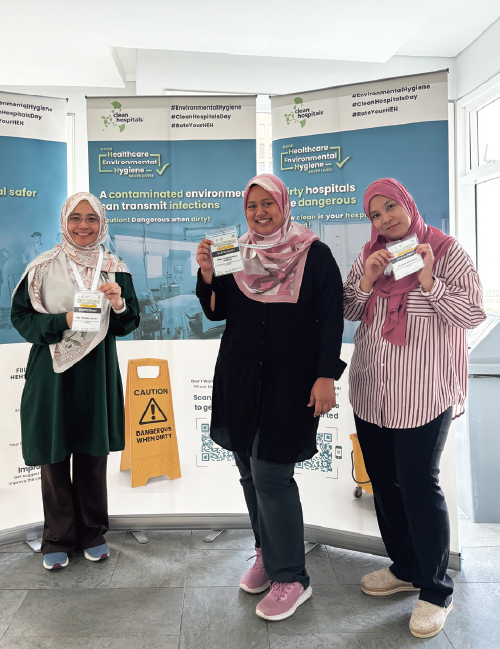 Participants posing in front of the event posters
