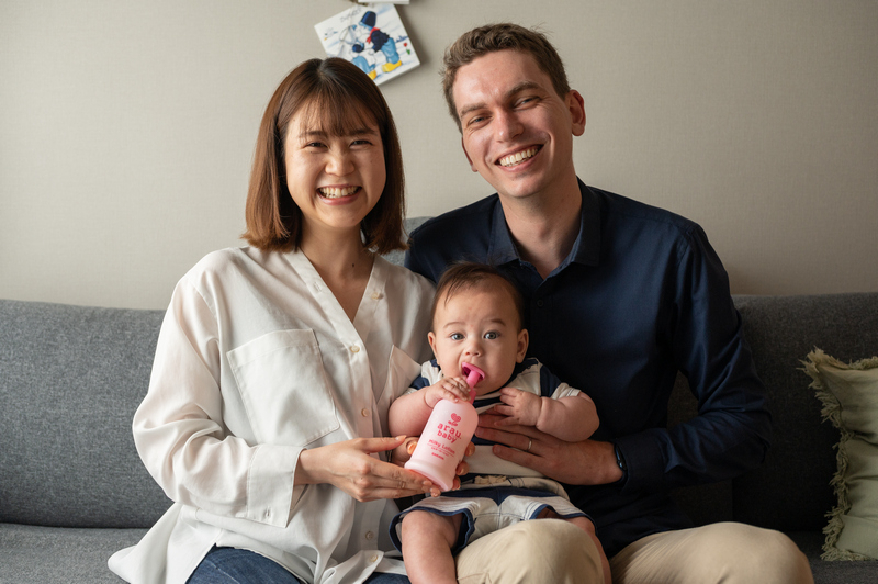 Wesley and Chihiro smile to the camera while Kaito bites on a arau.baby Milky Lotion bottle.